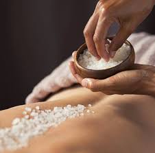 Picture of a person having a dead seas salt exfoliation on back.